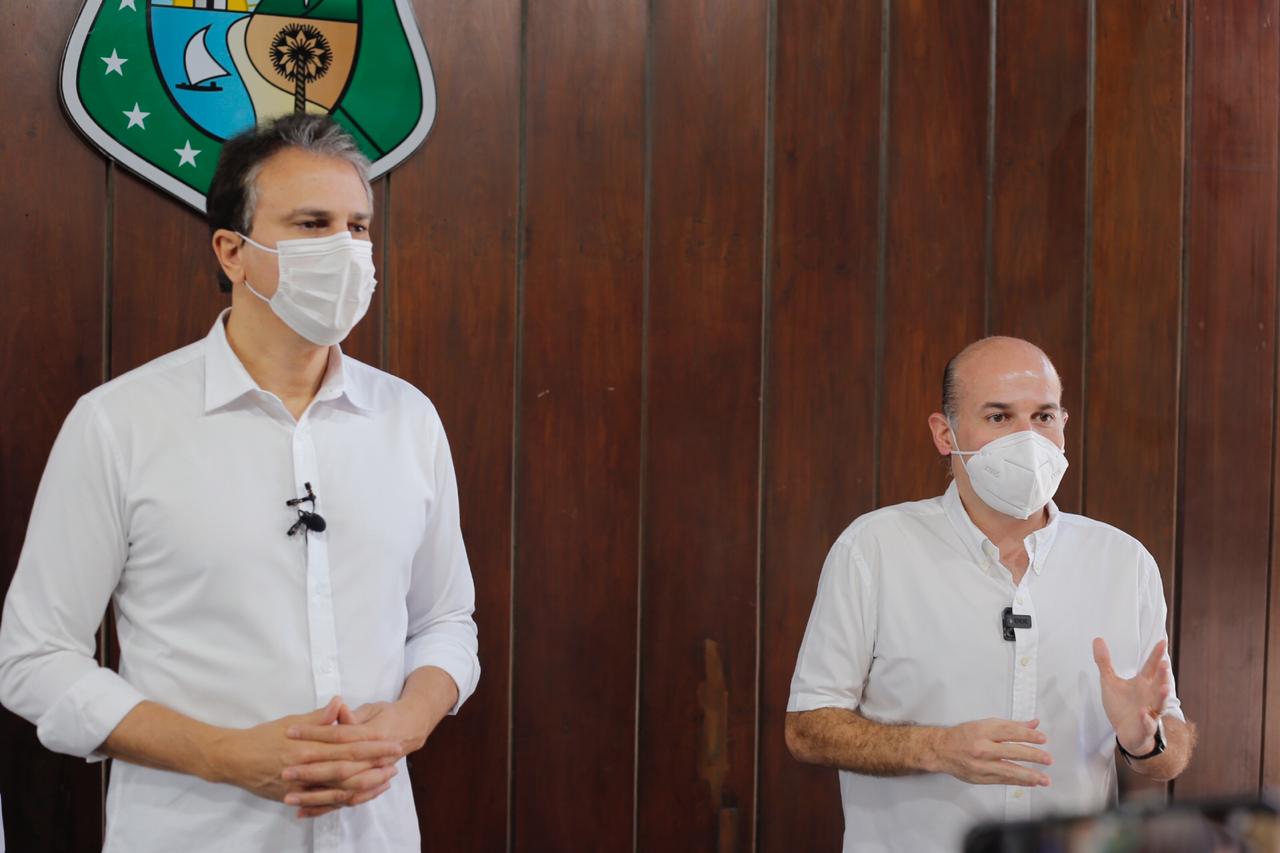 governador camilo santana e prefeito roberto cláudio. Ambos estão em pés na frente de microfones durante a coletiva